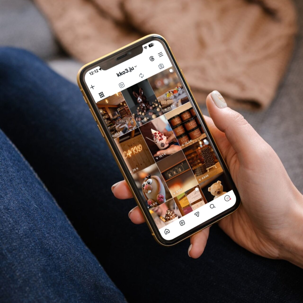 Main tenant un smartphone qui affiche le compte Instagram de la chocolaterie KKO3