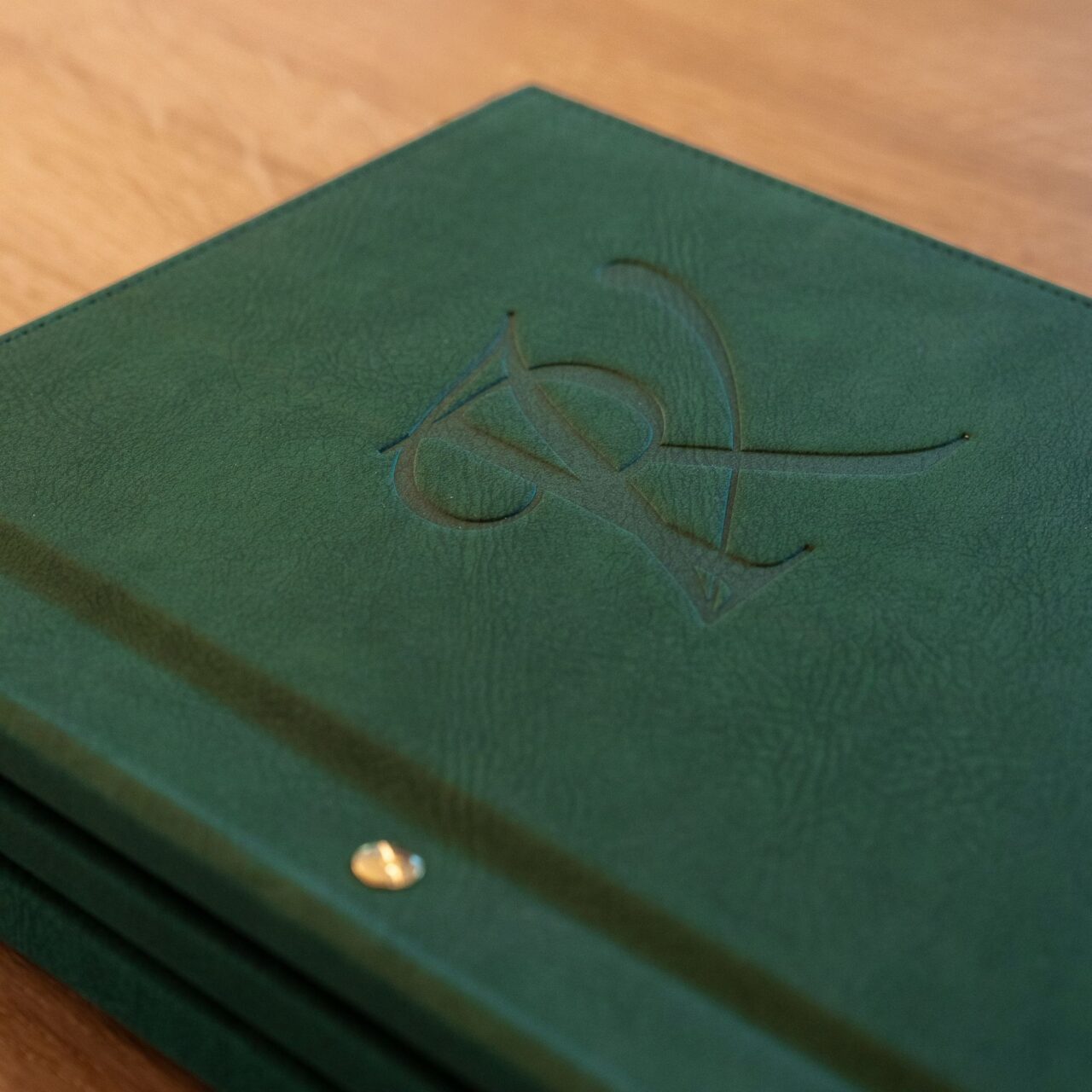 Couverture verte de la carte des mets du restaurant La Vallée, monogramme embossé