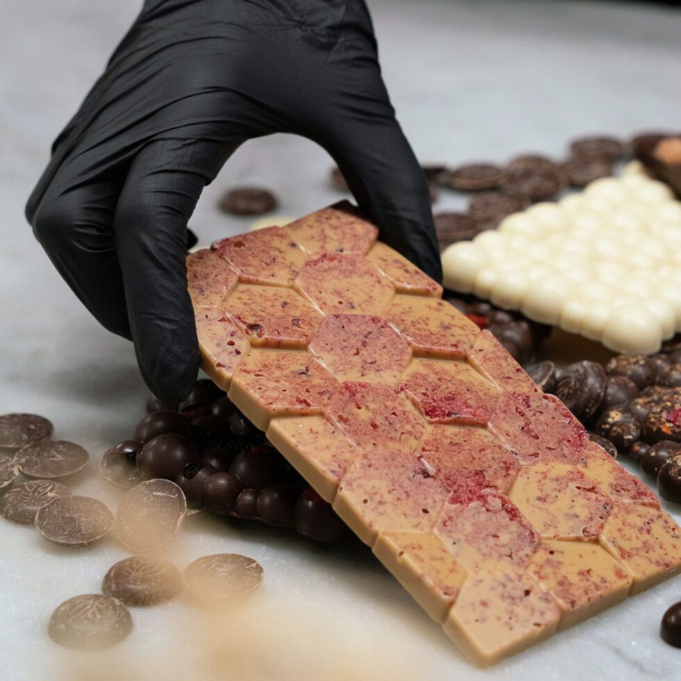 Tablette de chocolat aux éclats de fruits rouges sur un plan de travail