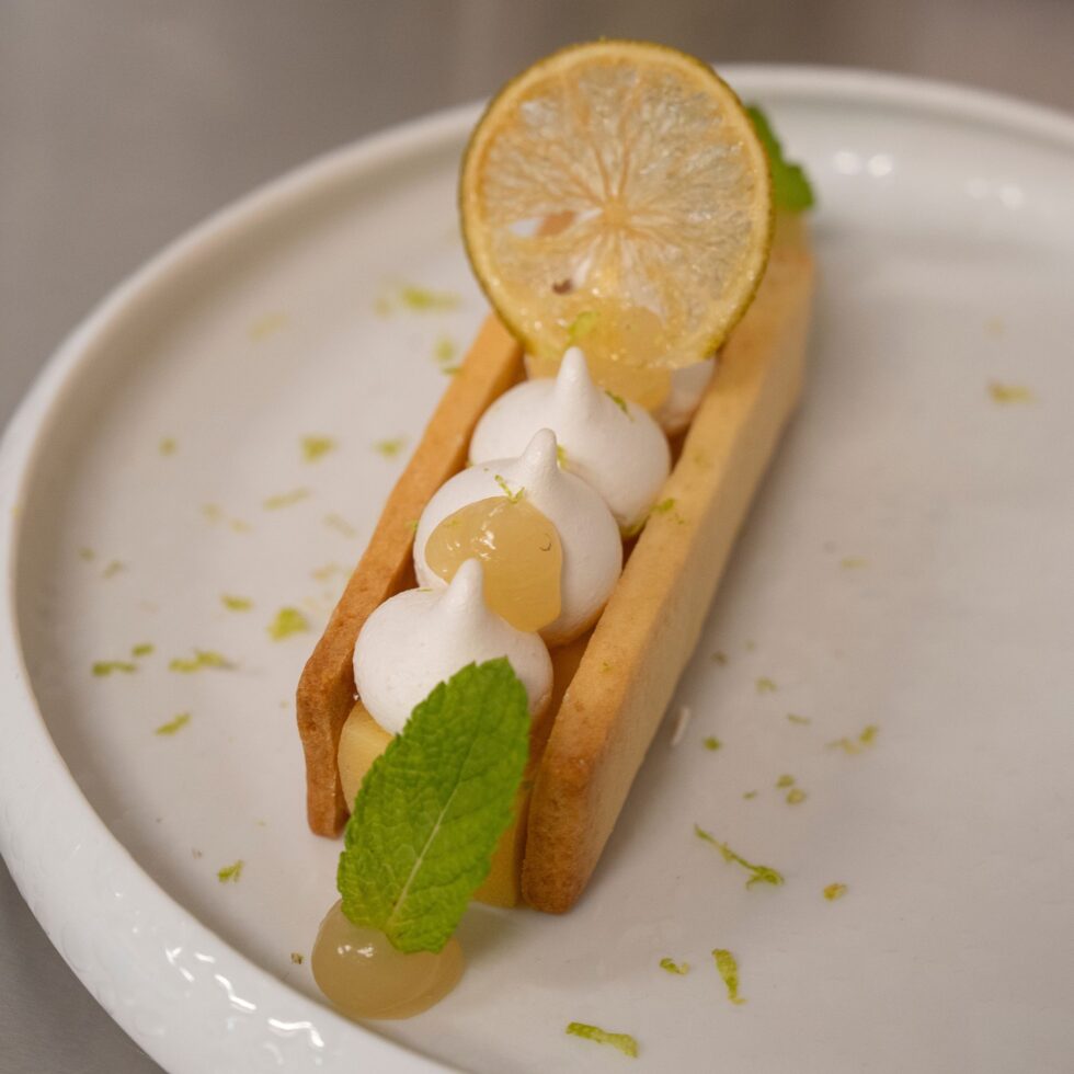 Tartelette au citron meringuée dressée sur assiette