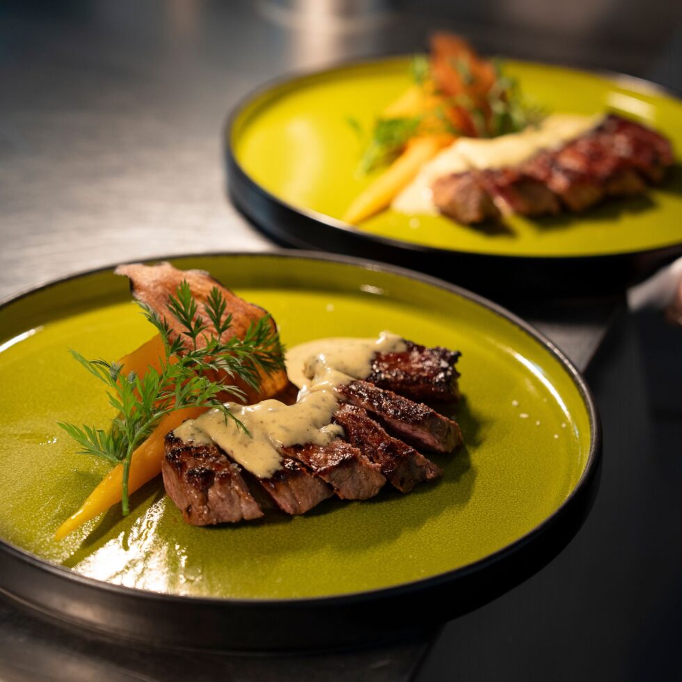 Deux assiettes jaunes de viande grillée et légumes