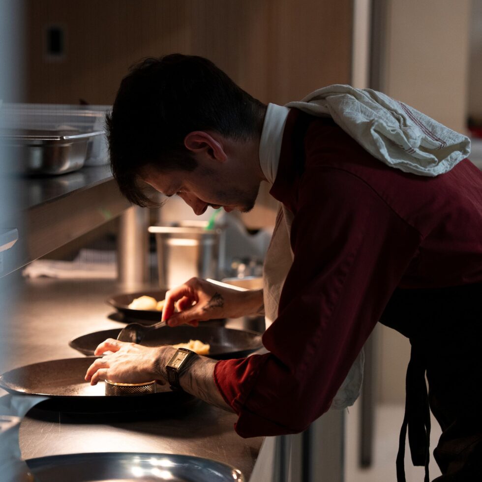 Cuisinier dressant une assiette en cuisine